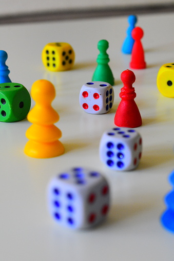 Don’t get angry board game dice cubes and figures of different colors on a white background stock photo, depth blur focus