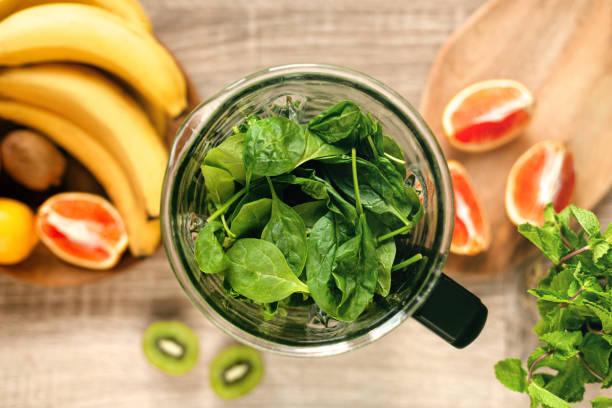 istock Fresh ripe spinach in blender on wooden table. Top view. 1436781439