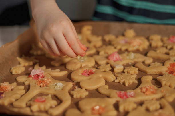 boy makes christmas cookies with caramel for celebration with his family