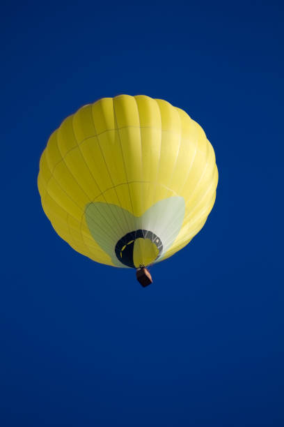 istock Yellow hot air balloon against a blue sky background. 1436786635