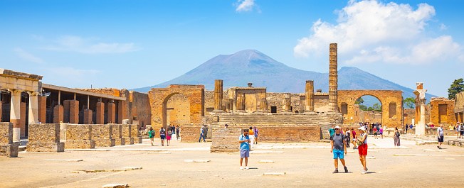 Pompeii, Italy - 17 May, 2022: Ancient Pompeii city ruins and Vesuvius volcano on background, popular tourist attraction