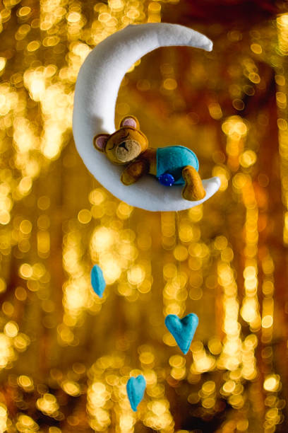 istock Felt teddy bear sewn from sleeping on the moon, baby hanging decorations for the nursery. 1436787326