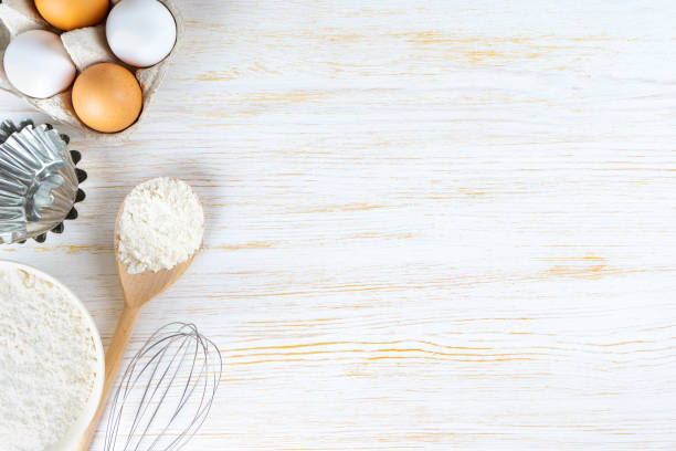 istock Baking ingredients flour, eggs, milk, bakeware on white wooden background with copy space 1436788279