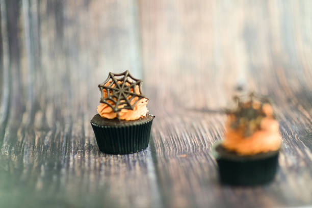 artisan chef preparing handmade with icing and chocolate spider vampire topper