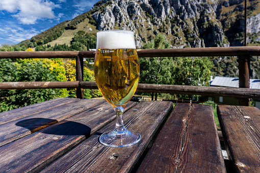 A glass of beer on a table at a restaurant  at Piani D’erna 375m above sea above Lecco on  Lake Como, Italy.