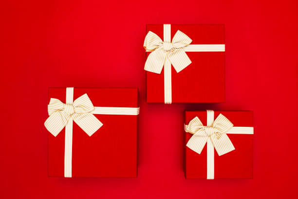 istock Red gift boxes tied with golden ribbons on a red background 1436793990