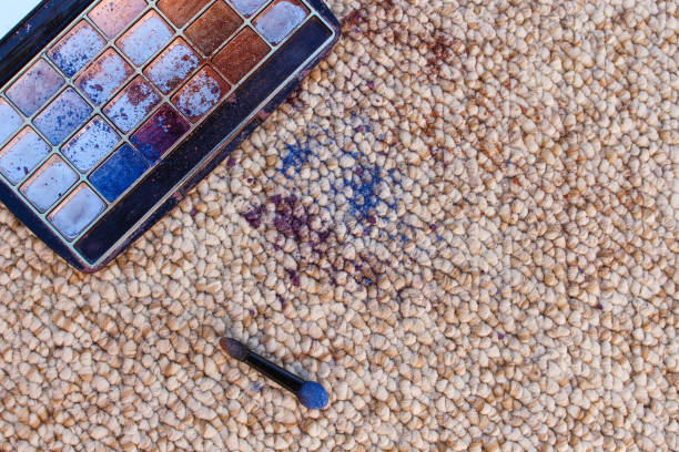 Eye shadow fell and scattered on carpet. Top view.