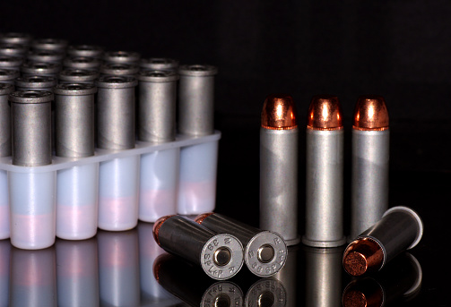 Group of pistol bullets on black glossy background
