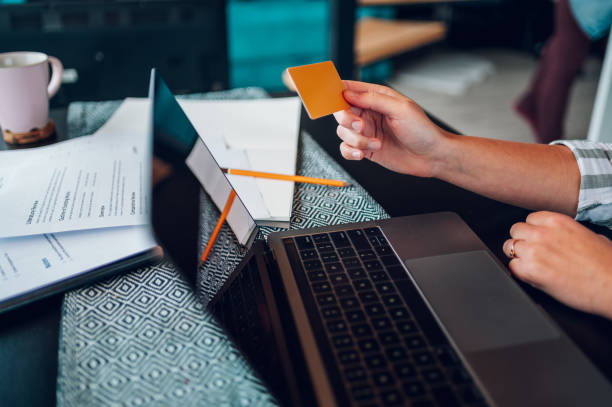 istock Woman hands using laptop and a credit card at home 1436805663