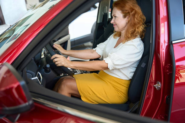 istock Happy woman sitting in new red auto 1436805946