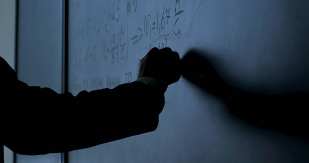 científico escribiendo fórmulas en pizarra. hand with chalk escribió fórmulas de física en primer plano de pizarra negra - formula blackboard complexity scientist fotografías e imágenes de stock