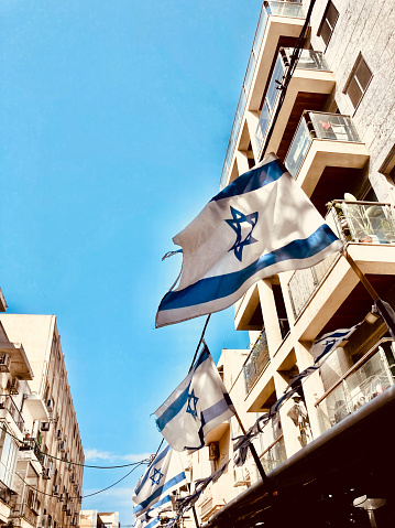Florentin, Tel Aviv, Israel- October 16, 2022. Israeli Flag at Street view of Florentin, Neighborhood in Tel Aviv, Israel. Up-and-coming part of the city, Florentin owes its hipster vibe to many bohemian cafes and its laid-back bars and galleries.