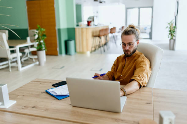 istock Coworkers sitting at the desk and working on their laptops 1436821787