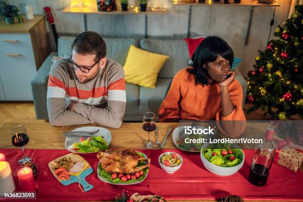 Couple Ignoring Each Other After An Argument Stock Photo - Download Image Now - Christmas, Arguing, Dinner