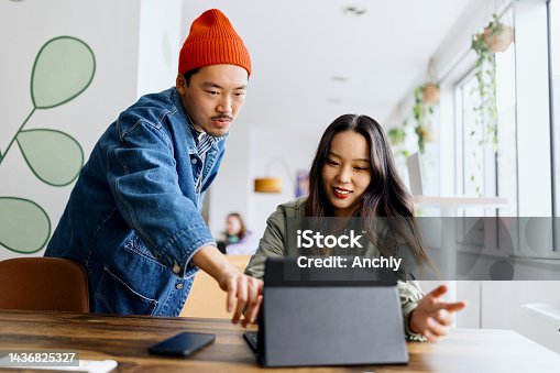 istock Coworkers team at work. Group of young business people in trendy casual wear working together in creative office 1436825327