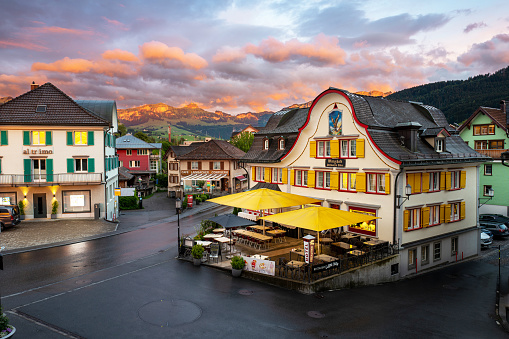 Appenzell, Switzerland - June 24, 2022: Sunset over the Swiss alps with the Adler Hotel in Appenzellerland Canton in the forground.  Appenzell is famous for cheese and beer and a popular destination to hike the Alpstein region.