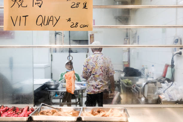 deux hommes à l’intérieur d’un magasin de viande barbecue vietnamien à cabramatta, sydney - butcher butchers shop meat store photos et images de collection