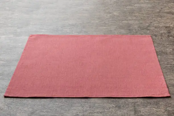 Perspective view of red tablecloth for food on cement background. Empty space for your design.