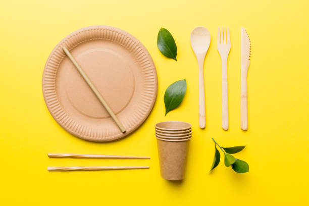 istock set of empty reusable disposable eco-friendly plates, cups, utensils on light white colored table background. top view. Biodegradable craft dishes. Recycling concept. Close-up 1436834393