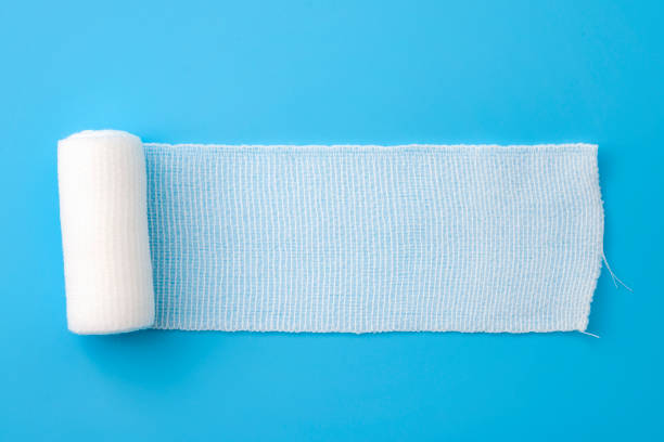 premiers soins, emballage de protection contre les blessures et pansement concept de pansement en coton propre bandage isolé sur fond bleu avec espace de copie - gauze photos et images de collection