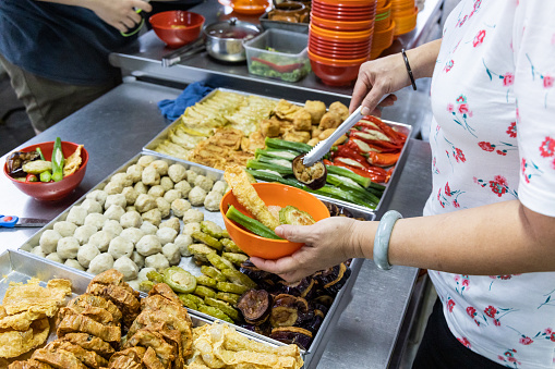 People selecting yong tau foo, delicious fried stuffed fish paste into chilli pepper, okra, aubergine, bean paste and other varieties in Malaysia