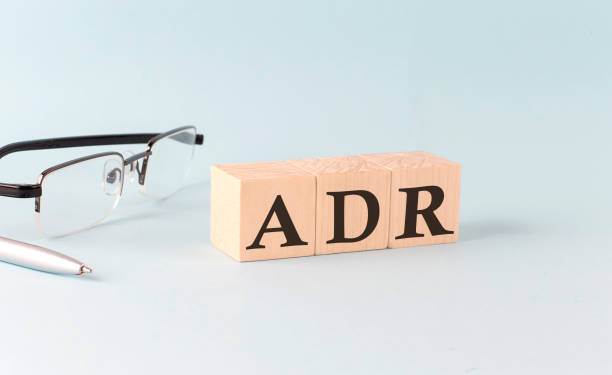 Text ADR - written on the wooden cubes on blue background stock photo