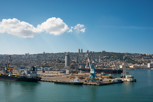 Haifa, Israel - Oct 10, 2022:  Port of Haifa , one of the three major international seaports in Israel, serves both passenger and merchant ships.  Baha'i Gardens is visible in the landscape background.