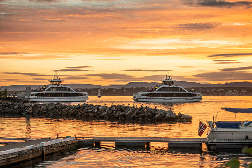 Electrical battery operated ferries crossing  in Oslo Fjord, 4k resolution at sunset