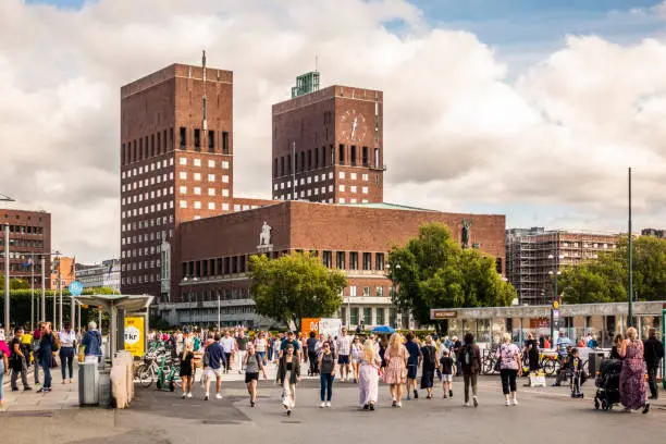 Photo of City Hall in Oslo with group of People walking in front.