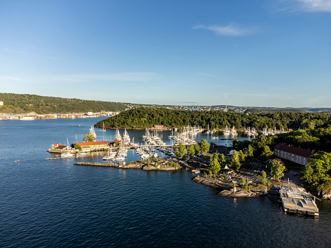 View of the Restaurant at Hovedoya Island with some boats and forest. The  drone photography was taken on a summer evening. Typical Norwegian island scene