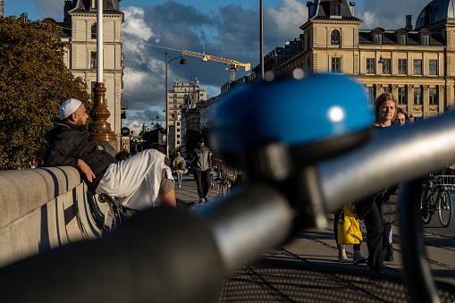 Copenhagen, Denmark Sept 30, 2022 A Muslim man sitting on  the Queen Louise Bridge over Stone Lake and a bicycle bell.
