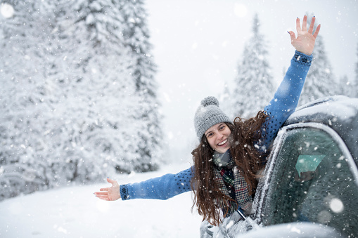 Smiley young woman welcoming winter during travel adventure.