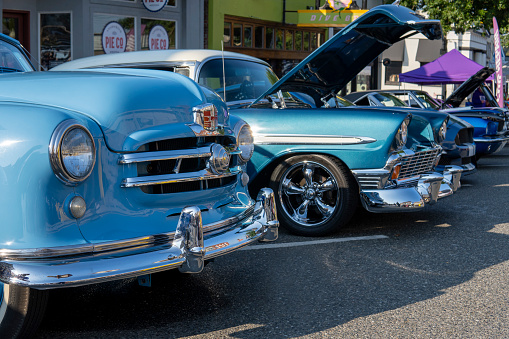 Headlights of Blue Nash Rambler 1952 and blue Chevrolet Bel Air 1955 at car exhibition. Snohomish, WA, USA - September 2022