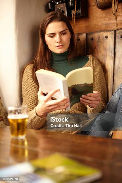 Foto de Mulher Lendo Com Uma Cerveja No Pub e mais fotos de stock de Ler - Ler, Cerveja, Livro