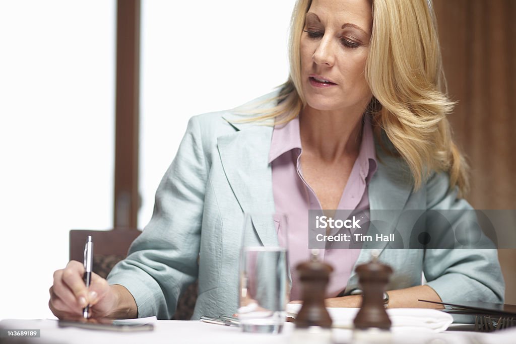 Donna d'affari scrive nel Café - Foto stock royalty-free di 40-44 anni