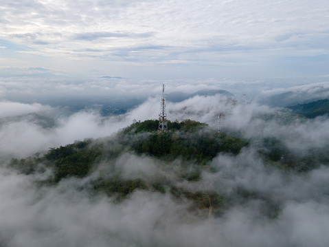 Aerial view 4G, 5G telecom tower in misty morning at peak of hill