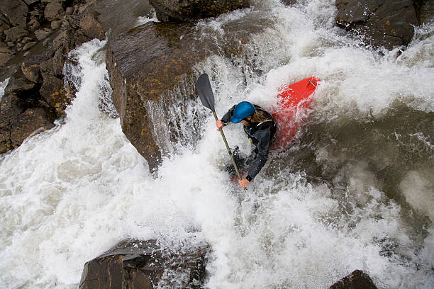 mann kanufahren auf rocky-wasserfall - wildwasserkanufahren stock-fotos und bilder