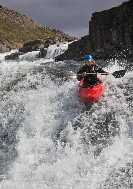 man canoeing over rocky waterfall - wildwasserkanufahren stock-fotos und bilder