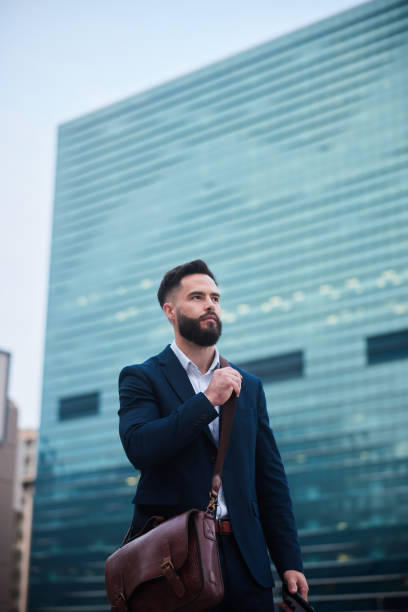 istock Confident businessman standing in front of an office building 1436898445