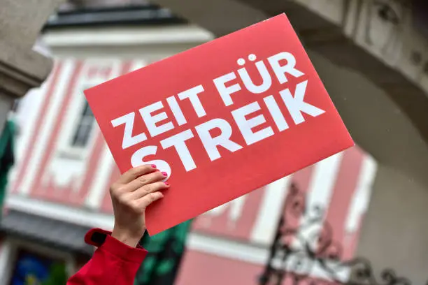 A red "Time for strike" sign at a demo in Linz