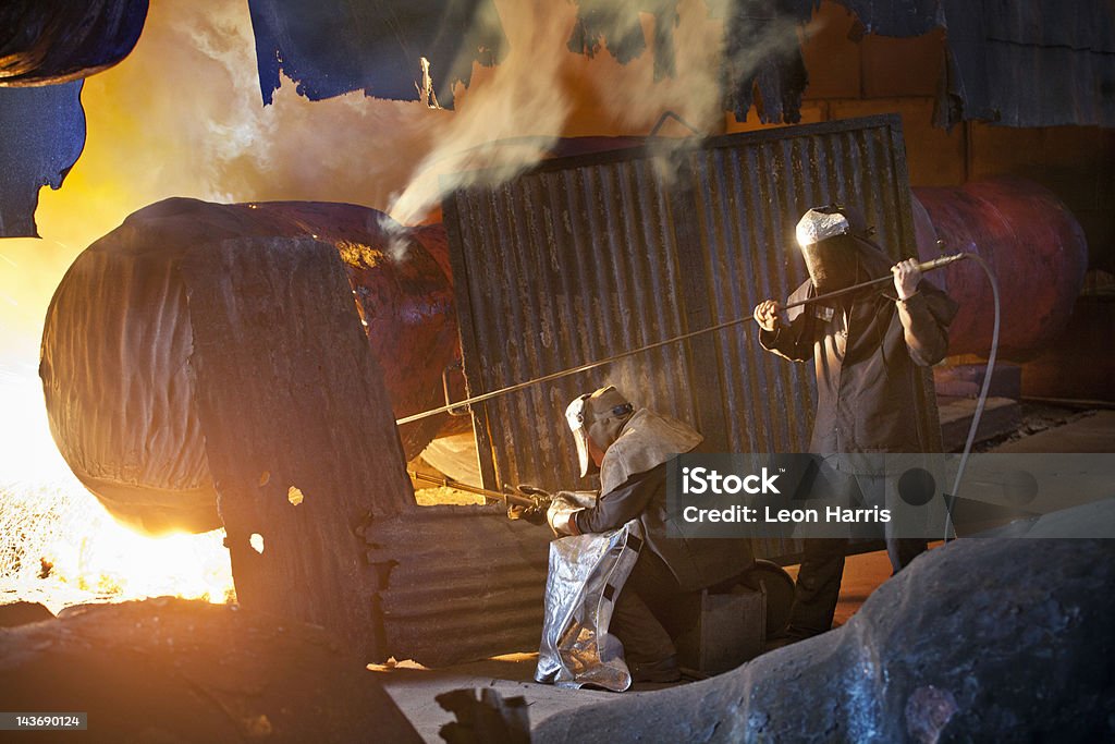 Welders at work in steel forge  Coworker Stock Photo