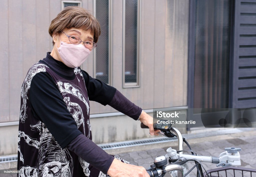 Senior woman with bicycle A senior woman riding a bicycle on a street in a residential area. Bicycle Stock Photo