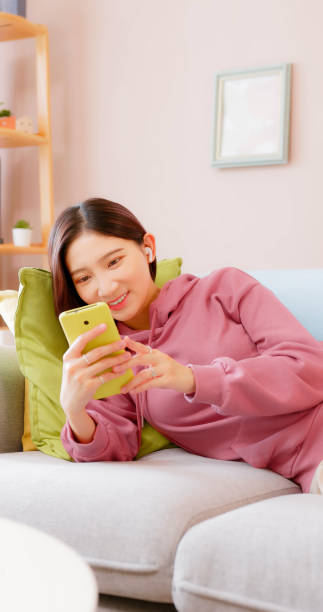 istock woman listen music on couch 1436906427