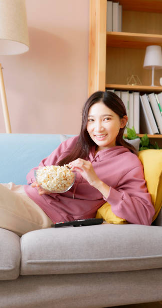 istock woman eat popcorn on couch 1436907599