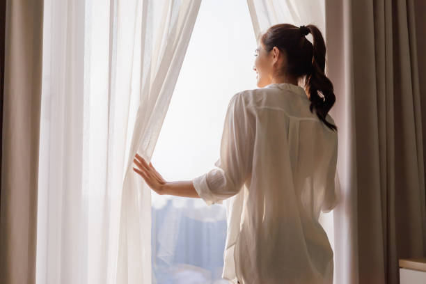 woman opens curtain asian woman walks to window and opens curtain happily in bedroom woman legs open stock pictures, royalty-free photos & images