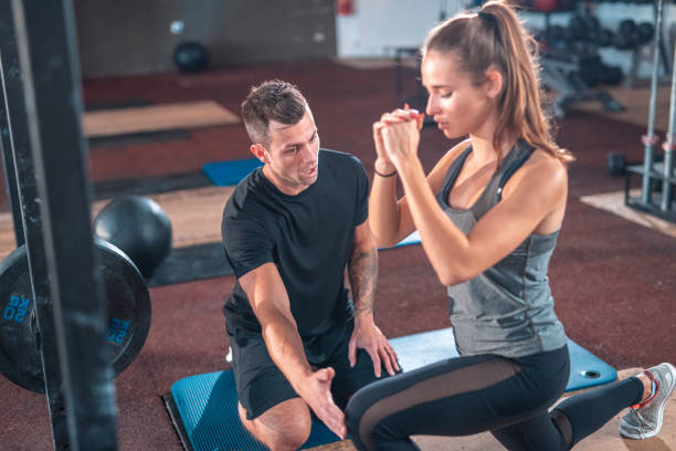 istock Male instructor teaching female athlete at gym 1436909138