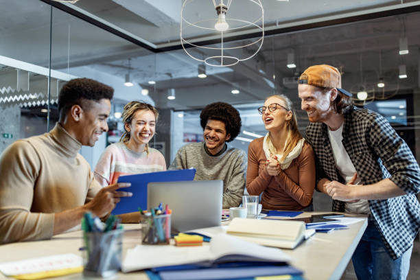 istock Cheerful start up team talking while having a meeting in the office. 1436909636