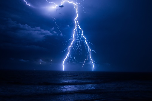 A flash of lightning over the sea thunderstorm clouds