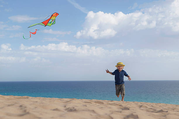 junge fliegender kite am strand - @jackstar stock-fotos und bilder
