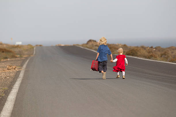 irmãos caminhando juntos em estrada rural - rear view family isolated child - fotografias e filmes do acervo